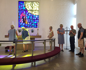 Et stort bål på en strand med tilskuere.