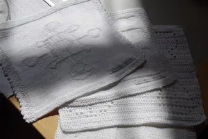 Strikkede hvide firkanter med kristne motiver.