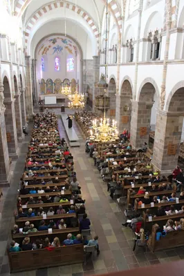 En forhøjet udsigt over en stor forsamling i et kirkeskib.