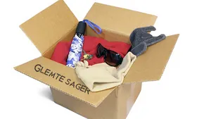 En papkasse mærket "Glemte Sager" med forskellige genstande.