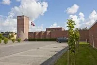 En moderne murstenskirke med et Dannebrog, der vajer.