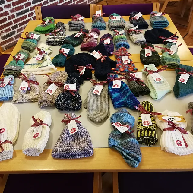 Bord med mange strikkede huer, vanter og sokker.