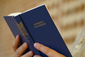 En person holder "Højskole-Sangbogen."