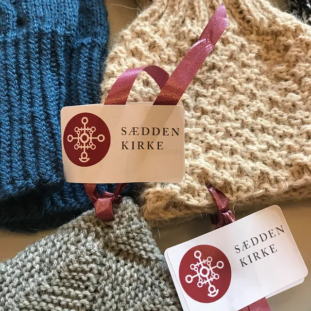 Strikkede genstande med "Sædden Kirke" mærker og bånd.